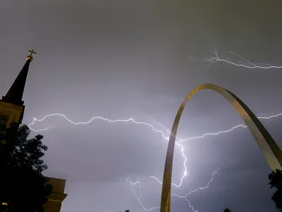 Lightning flashes in the sky behind the Gateway Arch, right, and Old Cathedral, left, as a line of thunderstorms moves through St. Louis, Wednesday, May 11, 2016. Thousands of Ameren Corp. customers in the St. Louis area are without power after the strong thunderstorm hit the region. (AP Photo/Jeff Roberson)