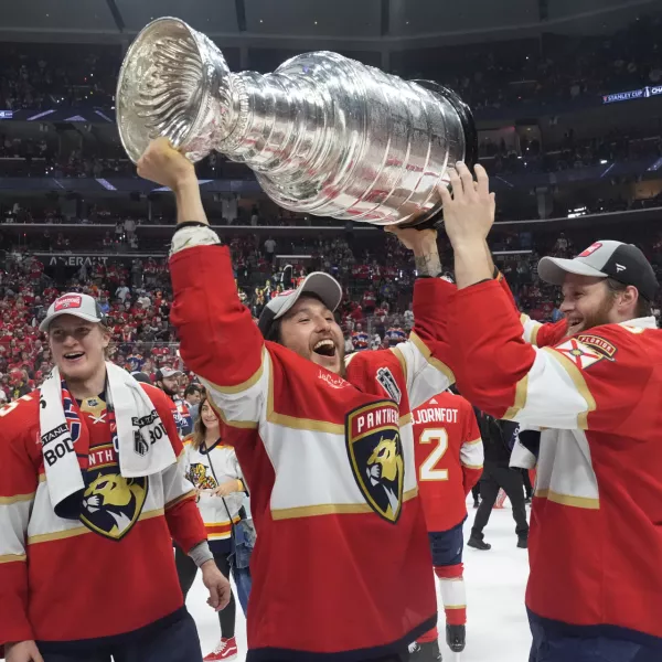 Florida Panthers defenseman Brandon Montour, center, lifts the Stanley Cup trophy after Game 7 of the NHL hockey Stanley Cup Final against the Edmonton Oilers, Monday, June 24, 2024, in Sunrise, Fla. The Panthers defeated the Oilers 2-1. (AP Photo/Wilfredo Lee)