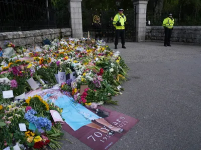 11 September 2022, United Kingdom, Balmoral: Flowers and tributes laid by members of the public at the gates of Balmoral in Scotland following the death of Queen Elizabeth II. The Queen's coffin will be transported on a six-hour journey from Balmoral to the Palace of Holyroodhouse in Edinburgh, where it will lie at rest. Photo: Owen Humphreys/PA Wire/dpa