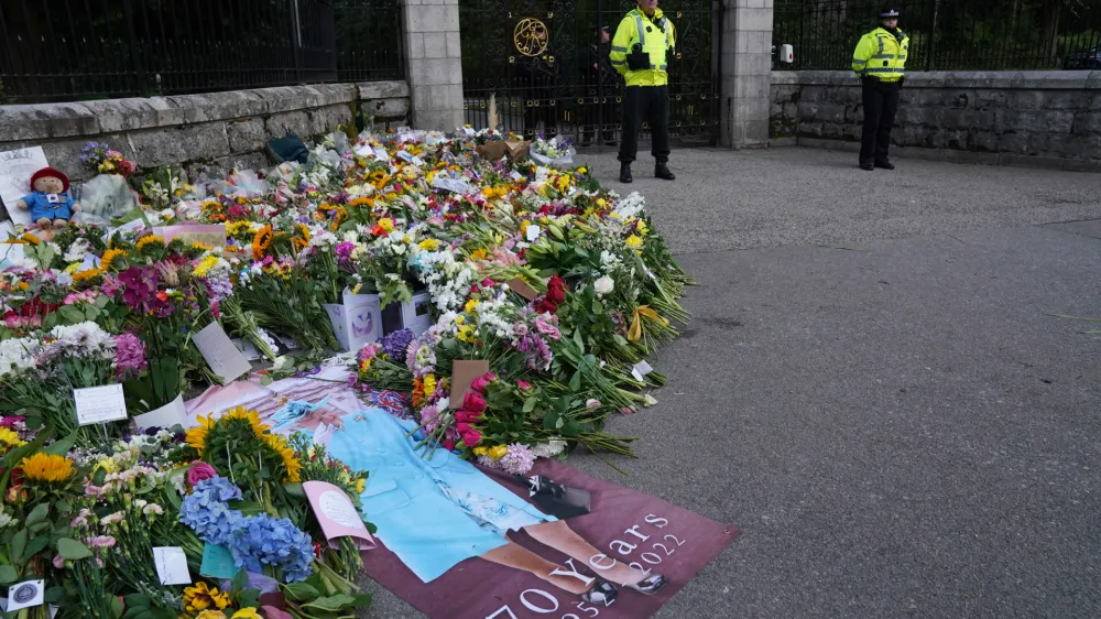 11 September 2022, United Kingdom, Balmoral: Flowers and tributes laid by members of the public at the gates of Balmoral in Scotland following the death of Queen Elizabeth II. The Queen's coffin will be transported on a six-hour journey from Balmoral to the Palace of Holyroodhouse in Edinburgh, where it will lie at rest. Photo: Owen Humphreys/PA Wire/dpa