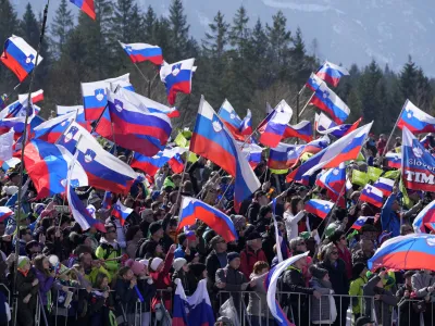 Fans wave Slovenian flags during the Men Flying Hill Individual competition at the FIS Ski Jumping World Cup in Planica, Slovenia, Sunday, March 27, 2022. (AP Photo/Darko Bandic)