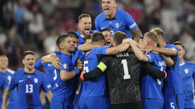 Slovenia's players celebrate at the end of a Group C match between the England and Slovenia at the Euro 2024 soccer tournament in Cologne, Germany, Tuesday, June 25, 2024. (AP Photo/Andreea Alexandru)