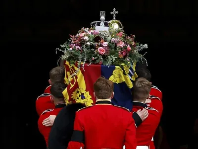 Pall bearers carry the coffin of Queen Elizabeth II with the Imperial State Crown resting on top into St. George's Chapel, in Windsor, England, Monday Sept. 19, 2022, for the committal service for Queen Elizabeth II. The Queen, who died aged 96 on Sept. 8, will be buried at Windsor alongside her late husband, Prince Philip, who died last year. (Jeff J Mitchell/Pool Photo via AP)