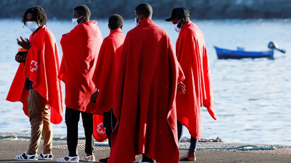 A group of migrants walks to a Red Cross tent to be attended after disembark from a Spanish coast guard vessel, in the port of Arguineguin, in the island of Gran Canaria, Spain, September 21, 2022. REUTERS/Borja Suarez