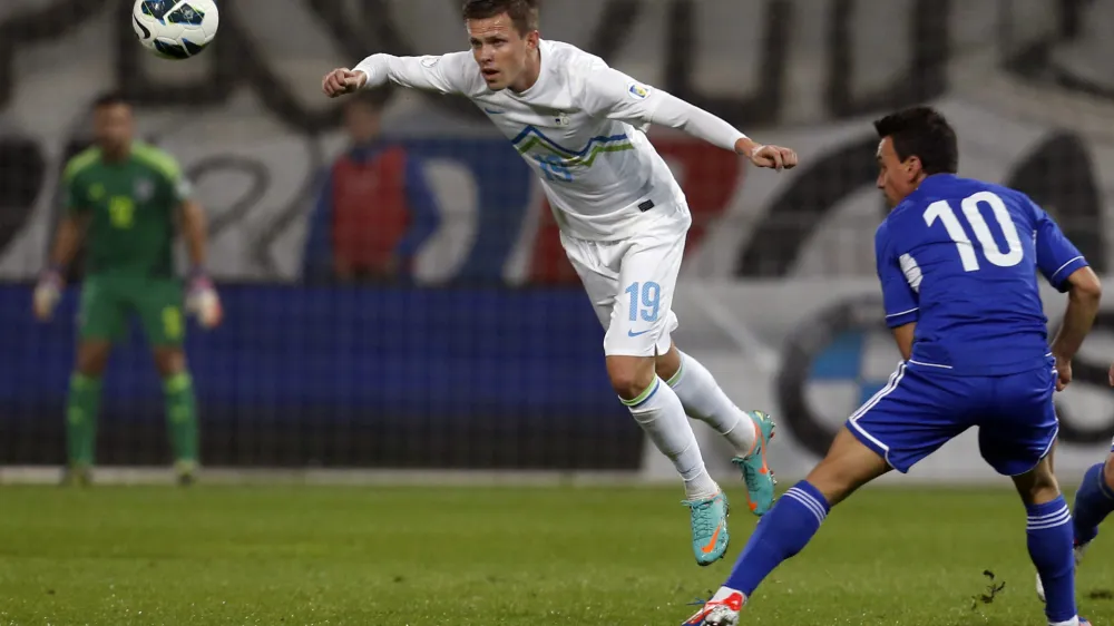 Cyprus' Constantinos Charalambides, right, is challenged by Slovenia's Josip Ilicic during their World Cup Group E qualifying soccer match at Ludski Vrt stadium in Maribor, Slovenia, Friday, Oct. 12, 2012. (AP Photo/Darko Bandic)