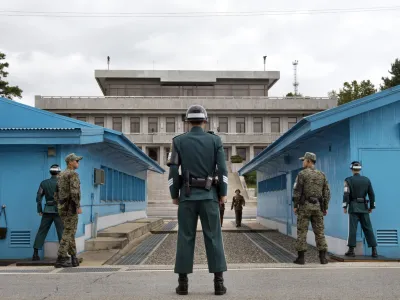 ﻿FILE - In this Sept. 30, 2013, file photo, South Korean soldiers look toward the North Korean side as a North Korean solder approaches the UN truce village building that sits on the border of the Demilitarized Zone (DMZ), the military border separating the two Koreas in Panmunjom, South Korea. The search is on for a venue to host a summit between President Donald Trump and North Koreaâ€™s Kim Jong Un. There are lots of caveats. Trump is being urged not to legitimize Kim by agreeing to talks in North Korea. And itâ€™s risky for Kim to travel to the U.S. So the leaders are more likely to meet in a neutral place, such as the demilitarized zone between the Koreas. (AP Photo/Jacquelyn Martin, File)