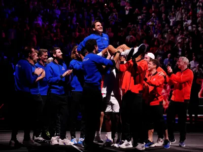 23 September 2022, United Kingdom, London: Team Europe's Roger Federer is lifted up by both teams after his final competitive match on day one of the Laver Cup at the O2 Arena. Photo: John Walton/PA Wire/dpa