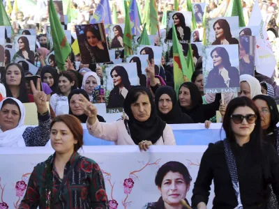 In this photo provided by Kurdish-run Hawar News Agency, Kurdish women hold portraits of Iranian Mahsa Amini, during a protest condemning her death in Iran, in the city of Qamishli, northern Syria, Monday, Sept. 26, 2022. Protests have erupted across Iran in recent days after Amini, a 22-year-old woman, died while being held by the Iranian morality police for violating the country's strictly enforced Islamic dress code. (Hawar News Agency via AP via AP)