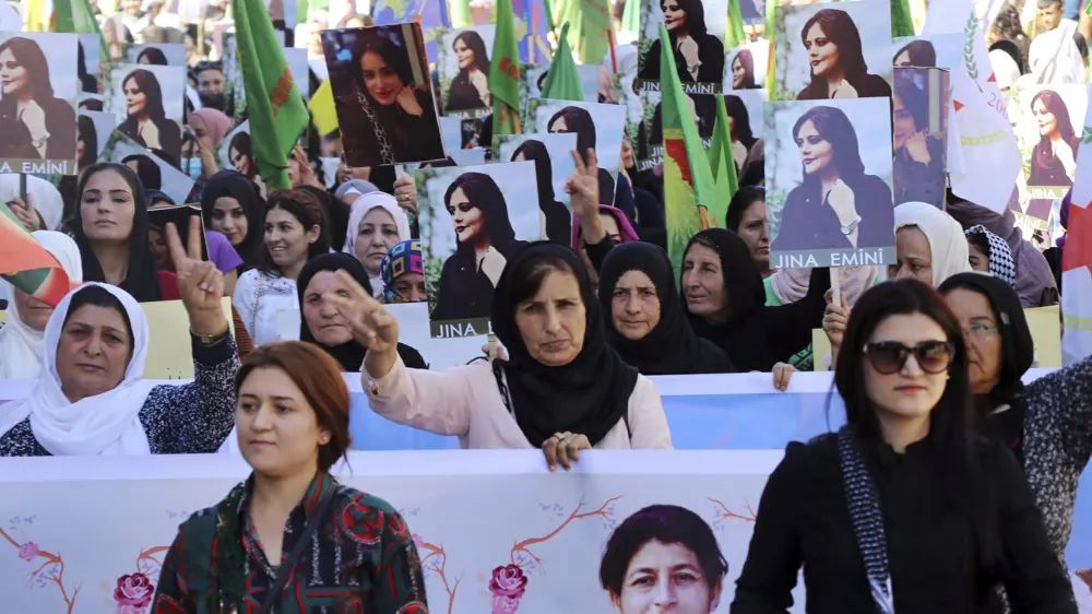 In this photo provided by Kurdish-run Hawar News Agency, Kurdish women hold portraits of Iranian Mahsa Amini, during a protest condemning her death in Iran, in the city of Qamishli, northern Syria, Monday, Sept. 26, 2022. Protests have erupted across Iran in recent days after Amini, a 22-year-old woman, died while being held by the Iranian morality police for violating the country's strictly enforced Islamic dress code. (Hawar News Agency via AP via AP)