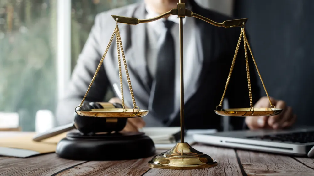 Business and lawyers discussing contract papers with brass scale on desk in office. Law, legal services, advice, justice and law concept picture with film grain effect