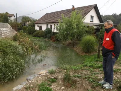 Visoka voda iz sicer nizkega potočka že spodjeda hišo družine Golouh v Sostrem. Foto: Luka Cjuha