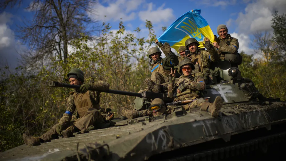 Ukrainian soldiers sit on an armoured vehicle as they drive on a road between Izium and Lyman in Ukraine, Tuesday Oct. 4, 2022. (AP Photo/Francisco Seco)