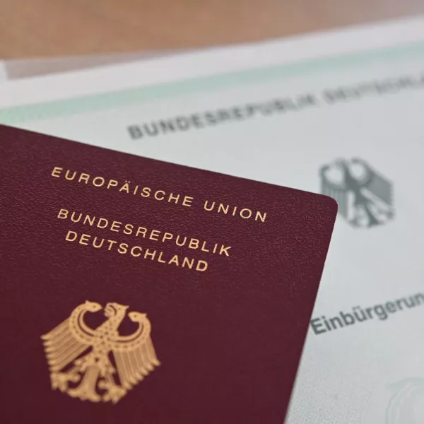 FILED - 24 June 2024, Baden-Wuerttemberg, Stuttgart: A German passport and a naturalization certificate lie on a table. Photo: Marijan Murat/dpa