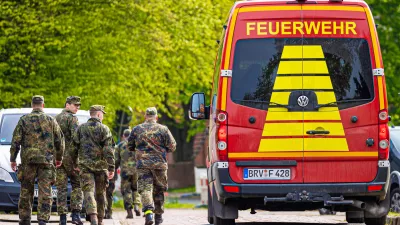 FILED - 27 April 2024, Lower Saxony, Elm: Soldiers of the German Armed Forces walk along a street in a residential area, past a fire department vehicle during the search operation for Arian a missing six-year-old child in northern Lower Saxony. A body found in the German state of Lower Saxony was on 27 June confirmed as that of Arian's, police said.There were no indications of foul play, investigators said. They did not reveal the cause of death to protect the family. Photo: Moritz Frankenberg/dpa