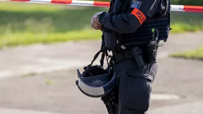 27 June 2024, Thuringia, Erfurt: A police officer stands in front of a police cordon near the suspected crime scene in Erfurt, where a man was shot dead. A large-scale police operation is currently underway. Photo: Jacob Schröter/dpa