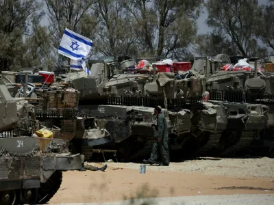 FILE PHOTO: An Israeli soldier walks near military vehicles, amid the ongoing conflict between Israel and the Palestinian Islamist group Hamas, near Israel's border with Gaza in southern Israel, May 29, 2024. REUTERS/Ronen Zvulun/File Photo