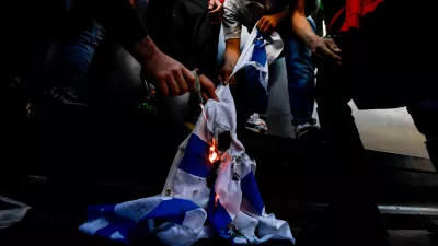 ﻿13 May 2021, Italy, Milan: Demonstrators burn an Israeli flag during a demonstration in solidarity with Palestinians amid the escalating flare-up of Israeli-Palestinian violence. Photo: Claudio Furlan/LaPresse via ZUMA Press/dpa