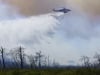 29 June 2024, Greece, Athens: A helicopter drops water to extinguish a large wildfire in the mountain of Parnitha. Photo: Nikolas Georgiou/ZUMA Press Wire/dpa