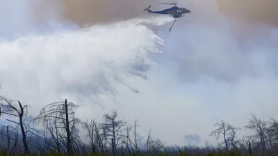 29 June 2024, Greece, Athens: A helicopter drops water to extinguish a large wildfire in the mountain of Parnitha. Photo: Nikolas Georgiou/ZUMA Press Wire/dpa