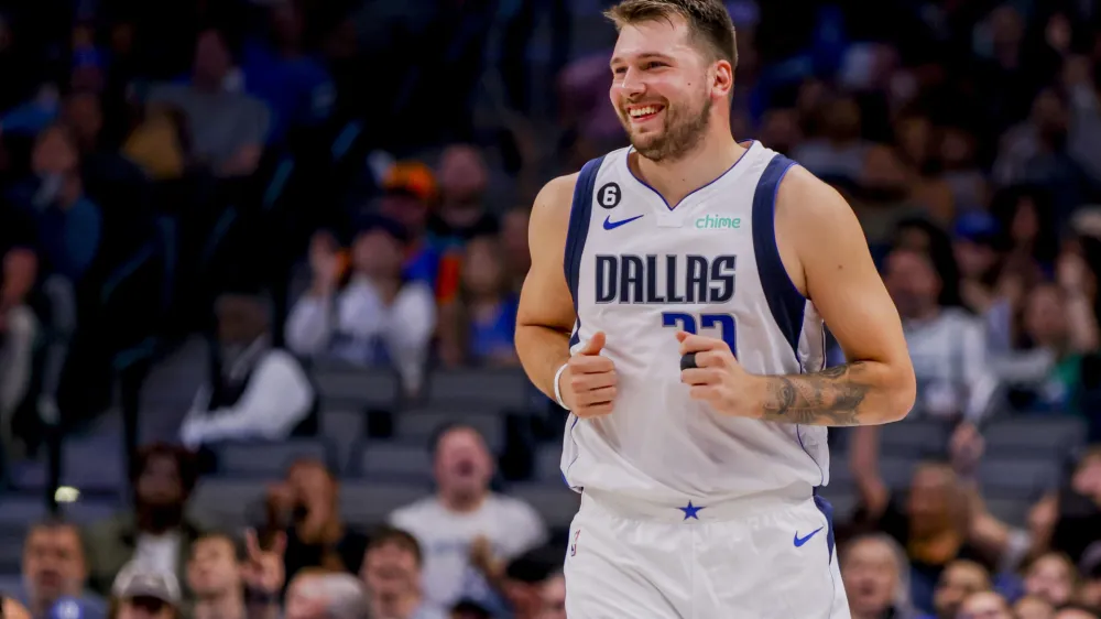 Dallas Mavericks point guard Luka Doncic smiles after making a basket during the first half of a preseason NBA basketball game against the Orlando Magic, Friday, Oct. 7, 2022, in Dallas. (AP Photo/Gareth Patterson)