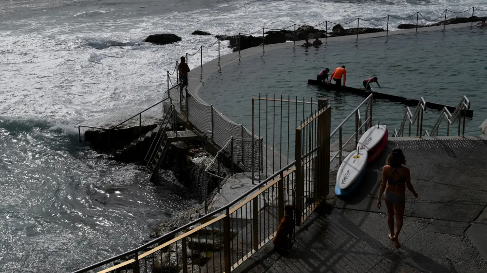 Members of the public are seen at the Bronte Baths in Sydney, Friday, October 7, 2022. More than a dozen rivers are flooding across NSW as a cloud band brings continued heavy falls and storms across NSW. (AAP Image/Bianca De Marchi) NO ARCHIVING