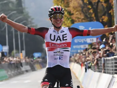 Tadej Pogacar celebrates as he crosses the finish line to win Il Lombardia cycling race from Bergamo to Como, Italy, Saturday, Oct. 8, 2022. (Gian Mattia D'Alberto/LaPresse via AP)