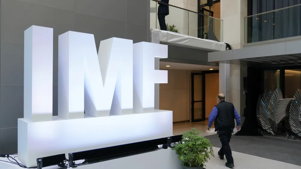 Attendees walk inside an atrium at the 2022 Annual Meetings of the International Monetary Fund and the World Bank Group, Monday, Oct. 10, 2022, in Washington. (AP Photo/Patrick Semansky)