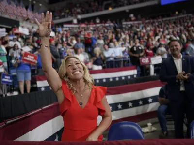 FILE - Rep. Marjorie Taylor Greene, R-Ga., waves at supporters before former President Donald Trump speaks at a rally in Wilkes-Barre, Pa., Sept. 3, 2022. Once shunned as a political pariah for her extremist rhetoric, the Georgia lawmaker who spent her first term in Congress stripped of institutional power by Democrats is being celebrated by Republicans and welcomed into the GOP fold. (AP Photo/Mary Altaffer, File)