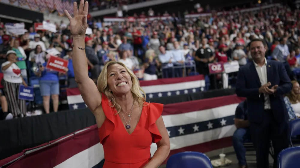 FILE - Rep. Marjorie Taylor Greene, R-Ga., waves at supporters before former President Donald Trump speaks at a rally in Wilkes-Barre, Pa., Sept. 3, 2022. Once shunned as a political pariah for her extremist rhetoric, the Georgia lawmaker who spent her first term in Congress stripped of institutional power by Democrats is being celebrated by Republicans and welcomed into the GOP fold. (AP Photo/Mary Altaffer, File)