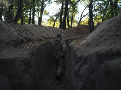 A Ukrainian serviceman checks the trenches dug by Russian soldiers in a retaken area in Kherson region, Ukraine, Wednesday, Oct. 12, 2022. (AP Photo/Leo Correa)