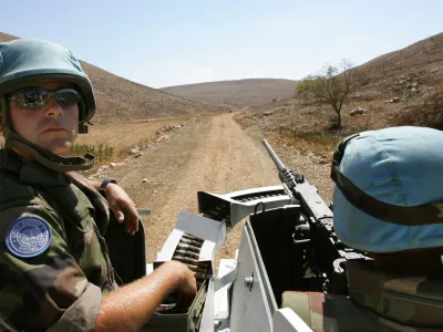 French U.N. peacekeepers with the 13th detachment Regiment Genie, from Valdahon, France, drive their armoured personnel carrier in an ordnance-littered area near the village of Kawneen, southern Lebanon, Wednesday, Oct. 4, 2006. The French are clearing the area of unexploded ordnance as part of the U.N. mission aimed at cementing the cease-fire between Hezbollah and Israel. (AP Photo/Peter Dejong)