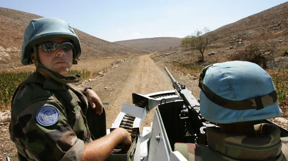 French U.N. peacekeepers with the 13th detachment Regiment Genie, from Valdahon, France, drive their armoured personnel carrier in an ordnance-littered area near the village of Kawneen, southern Lebanon, Wednesday, Oct. 4, 2006. The French are clearing the area of unexploded ordnance as part of the U.N. mission aimed at cementing the cease-fire between Hezbollah and Israel. (AP Photo/Peter Dejong)