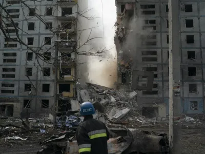 FILE - A firefighter looks at a part of a wall falling from the residential building that was heavily damaged after a Russian attack in Zaporizhzhia, Ukraine, Sunday, Oct. 9, 2022. Russia has declared its intention to increase its targeting of Ukraine's power, water and other vital infrastructure in its latest phase of the nearly 8-month-old war. (AP Photo/Leo Correa, File)