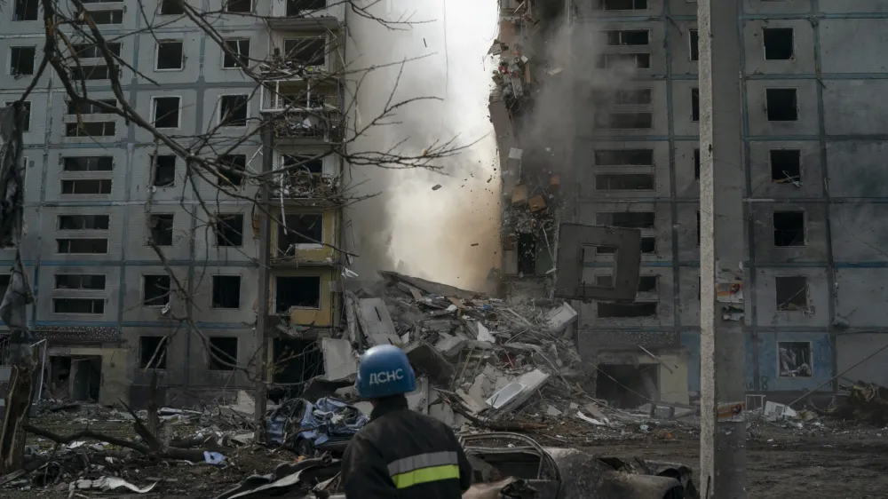 FILE - A firefighter looks at a part of a wall falling from the residential building that was heavily damaged after a Russian attack in Zaporizhzhia, Ukraine, Sunday, Oct. 9, 2022. Russia has declared its intention to increase its targeting of Ukraine's power, water and other vital infrastructure in its latest phase of the nearly 8-month-old war. (AP Photo/Leo Correa, File)