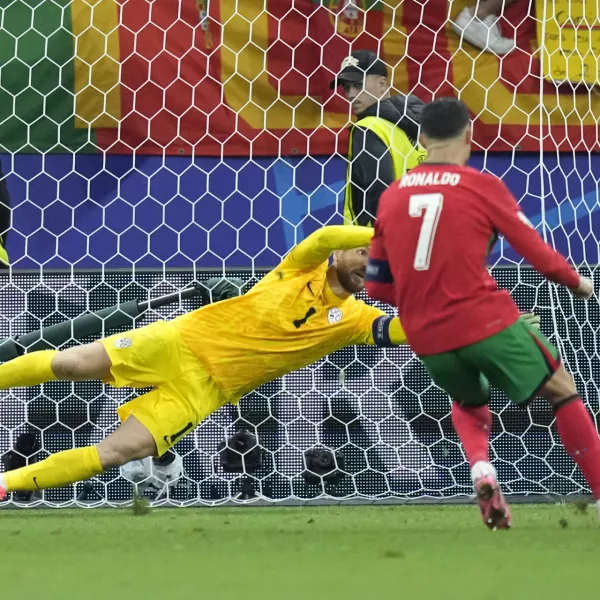 Slovenia's goalkeeper Jan Oblak blocks a penalty kick by Portugal's Cristiano Ronaldo (7) during a round of sixteen match at the Euro 2024 soccer tournament in Frankfurt, Germany, Monday, July 1, 2024. (AP Photo/Ebrahim Noroozi)