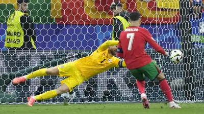 Slovenia's goalkeeper Jan Oblak blocks a penalty kick by Portugal's Cristiano Ronaldo (7) during a round of sixteen match at the Euro 2024 soccer tournament in Frankfurt, Germany, Monday, July 1, 2024. (AP Photo/Ebrahim Noroozi)