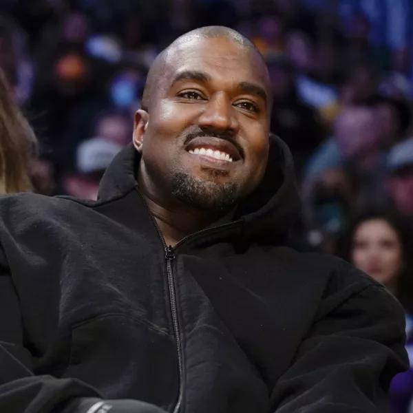 FILE - Kanye West watches the first half of an NBA basketball game between the Washington Wizards and the Los Angeles Lakers in Los Angeles, on March 11, 2022. Former President Donald Trump had dinner Tuesday, Nov. 22, at his Mar-a-Lago club with the rapper formerly known as Kanye West, who is now known as Ye, as well as Nick Fuentes, a far-right activist who has used his online platform to spew antisemitic and white supremacist rhetoric. (AP Photo/Ashley Landis, File)