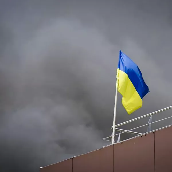 In this photo released by the Dnipro Regional Administration, Ukrainian flag waves as smoke rises after Russia's missile attack in Dnipro, Ukraine, Wednesday, July 3, 2024. (Dnipro Regional Administration via AP)