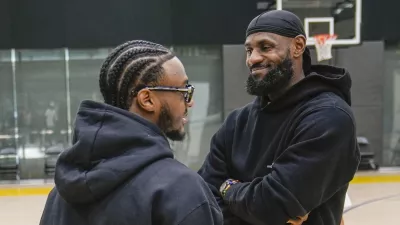 Los Angeles Lakers draft pick Bronny James, left, and his father, LeBron James, share a light moment as they arrive for the NBA basketball team's news conference in El Segundo, Calif., Tuesday, July 2, 2024 (AP Photo/Damian Dovarganes)