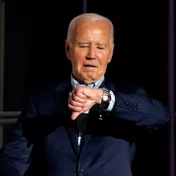 U.S. President Joe Biden looks at his watch as he stands on the balcony during an Independence Day celebration on the South Lawn of the White House in Washington, U.S., July 4, 2024. REUTERS/Elizabeth Frantz