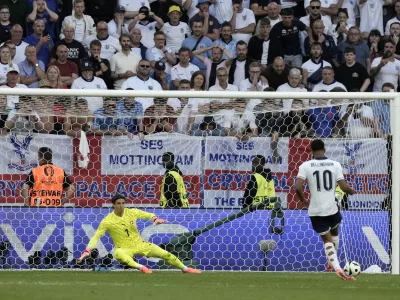 England's Jude Bellingham shoots to score during penalty shootout of the quarterfinal match between England and Switzerland at the Euro 2024 soccer tournament in Duesseldorf, Germany, Saturday, July 6, 2024. (AP Photo/Thanassis Stavrakis)