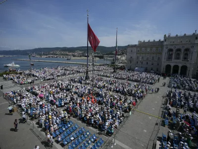 People attend a mass presided over by Pope Francis in Trieste's monumental square Piazza dell'Unita' d'Italia, in northern Italy, Sunday, July 7, 2024. The pope is in Trieste for a one-day visit. (AP Photo/Alessandra Tarantino)