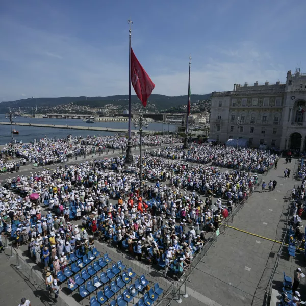 People attend a mass presided over by Pope Francis in Trieste's monumental square Piazza dell'Unita' d'Italia, in northern Italy, Sunday, July 7, 2024. The pope is in Trieste for a one-day visit. (AP Photo/Alessandra Tarantino)