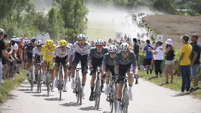 The pack with Denmark's Jonas Vingegaard, in second position, and Slovenia's Tadej Pogacar, wearing the overall leader's yellow jersey, rides on a gravel road during the ninth stage of the Tour de France cycling race over 199 kilometers (123.7 miles) with start and finish in Troyes, France, Sunday, July 7, 2024. (Bernard Papon/Pool Photo via AP)