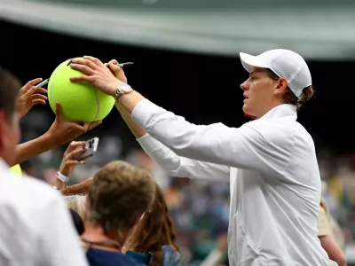 Tennis - Wimbledon - All England Lawn Tennis and Croquet Club, London, Britain - July 7, 2024 Italy's Jannik Sinner signs autographs for fans after winning his fourth round match against Ben Shelton of the U.S. REUTERS/Hannah Mckay