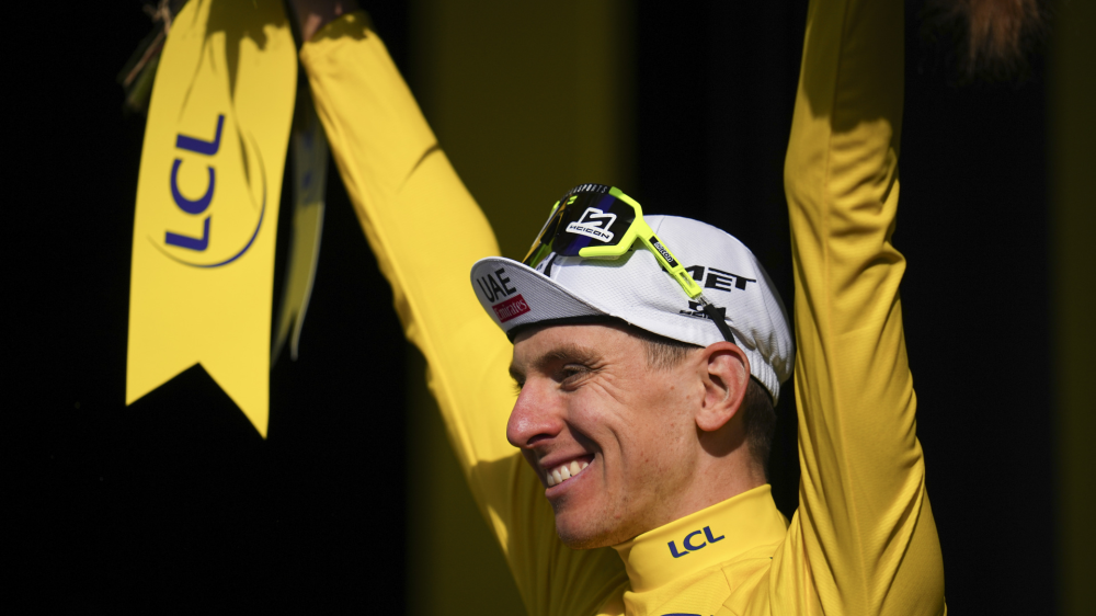 Slovenia's Tadej Pogacar, wearing the overall leader's yellow jersey, celebrates on the podium after the ninth stage of the Tour de France cycling race over 199 kilometers (123.7 miles) with start and finish in Troyes, France, Sunday, July 7, 2024. (AP Photo/Daniel Cole)