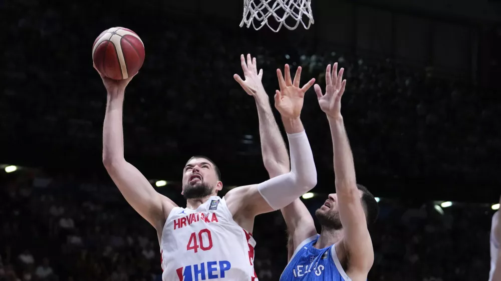 Croatia's Ivica Zubac, left, jumps to score against Greece's Georgia's Papagiannis, right,during a during a FIBA Olympic Qualifying basketball final, at the Peace and Friendship stadium at Athens' port city of Piraeus, Sunday, July 7, 2024. (AP Photo/Petros Giannakouris)