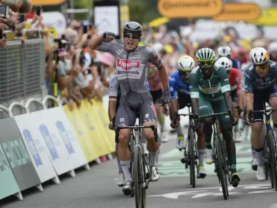 Belgium's Jasper Philipsen celebrates as he crosses the finish line ahead of Germany's Pascal Ackermann, left, Colombia's Fernando Gavira, center in blue, and Eritrea's Biniam Girmay, wearing the best sprinter's green jersey, to win the tenth stage of the Tour de France cycling race over 187.3 kilometers (116.4 miles) with start in Orleans and finish in Saint-Amand-Montrond, France, Tuesday, July 9, 2024. (AP Photo/Jerome Delay)