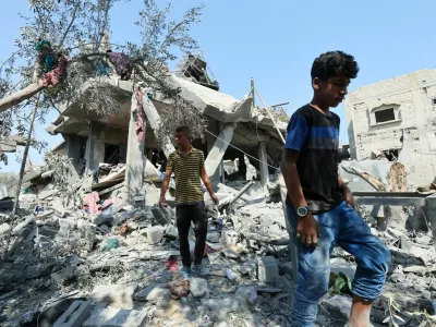 Palestinians inspect a house destroyed in an Israeli strike, amid the Israel-Hamas conflict, in Nusairat refugee camp, in the central Gaza Strip, July 9, 2024. REUTERS/Ramadan Abed