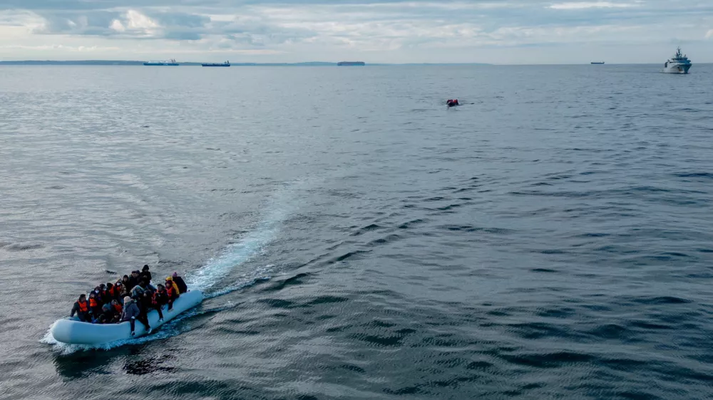 FILE PHOTO: In this drone view two inflatable dinghies carrying migrants pass a French navy vessel as they make their way towards England in the English Channel, Britain, May 4, 2024. REUTERS/Chris J. Ratcliffe/File Photo